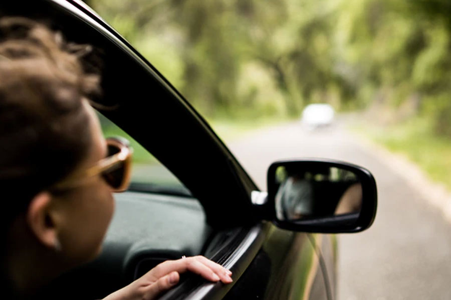 Girl looking out car window | Auto Insurance